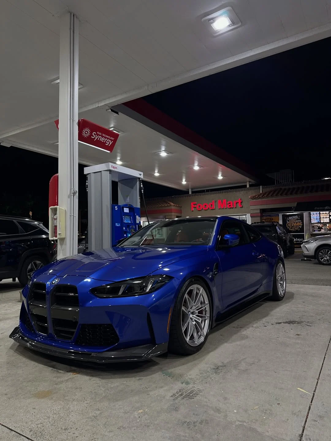 Nat's blue G82 M4 on silver wheels at a night fuel stop